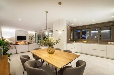 a kitchen and dining room with a wooden table and chairs at SIAT VIVIENDAS Villa carretera LA BARROSA in Chiclana de la Frontera