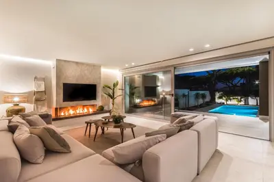 a living room with a large couch and a fireplace at SIAT VIVIENDAS Villa carretera LA BARROSA in Chiclana de la Frontera