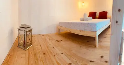 a bedroom with a bed and a wooden floor at Suite San Mateos 15 in Jerez de la Frontera