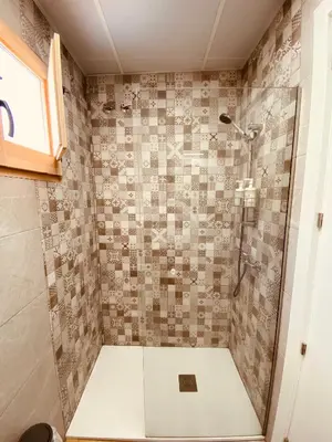 a bathroom with a shower with a tile wall at Suite San Mateos 15 in Jerez de la Frontera