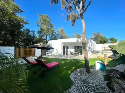 a yard with two chairs and an umbrella at Minichalet El Molino 1 in Chiclana de la Frontera