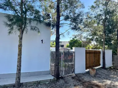 a white house with a gate and a fence at Minichalet El Molino 1 in Chiclana de la Frontera