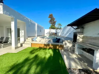 a modern house with a green lawn in the backyard at Minichalet El Molino 1 in Chiclana de la Frontera