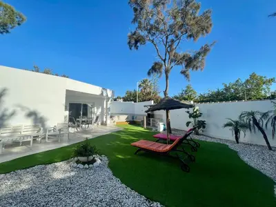 a yard with a chair and an umbrella at Minichalet El Molino 1 in Chiclana de la Frontera