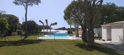 a large swimming pool in a park with trees at Hacienda Laguna Seca - Apart. Jazmin in Chiclana de la Frontera