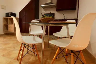 a dining room table with white chairs in a kitchen at Hacienda Laguna Seca - Apart. Jazmin in Chiclana de la Frontera