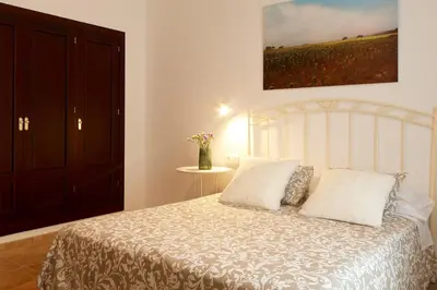 a bedroom with a white bed with two pillows at Hacienda Laguna Seca - Apart. Jazmin in Chiclana de la Frontera