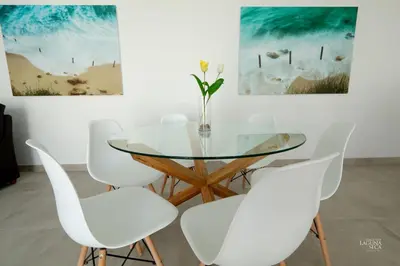 a dining room with a glass table and white chairs at Hacienda Laguna Seca - Apart. Buganvilla in Chiclana de la Frontera