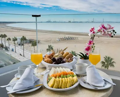 a table with a breakfast with a view of the beach at Hotel Puerto Bahía & Spa in El Puerto de Santa María
