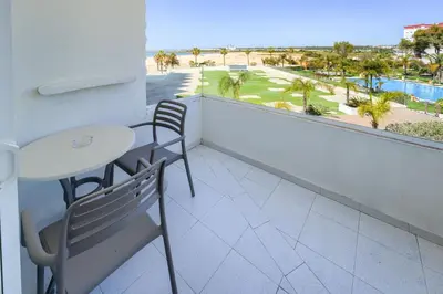 a balcony with a table and chairs and a view of the beach at Hotel Puerto Bahía & Spa in El Puerto de Santa María