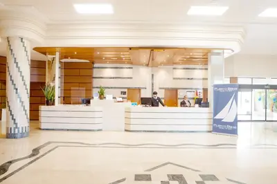 a lobby of an office building with a man sitting at a desk at Hotel Puerto Bahía & Spa in El Puerto de Santa María