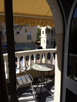 a patio with a table and chairs on a balcony at Hostal Restaurante La Giralda in Rota