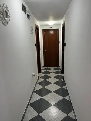 a hallway with a door and a checkered floor at Hostal Restaurante La Giralda in Rota