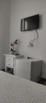 a bedroom with a bed and a tv on a wall at Hostal Restaurante La Giralda in Rota