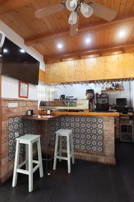 a kitchen with two stools and a counter in a kitchen at Hostal Restaurante La Giralda in Rota