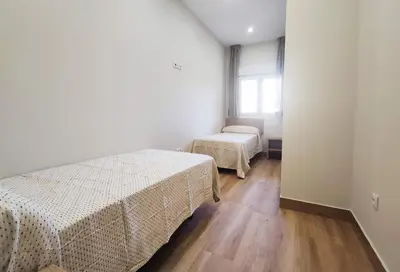 a bedroom with two beds and a window at APARTAMENTOS SANLUCAR CASA A in Sanlúcar de Barrameda