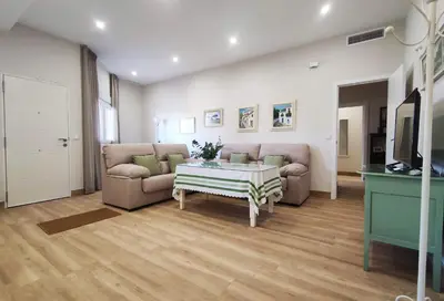 a living room with two couches and a table at APARTAMENTOS SANLUCAR CASA A in Sanlúcar de Barrameda