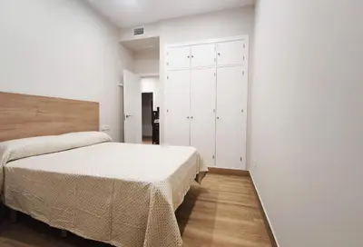 a bedroom with two beds and a closet at APARTAMENTOS SANLUCAR CASA A in Sanlúcar de Barrameda