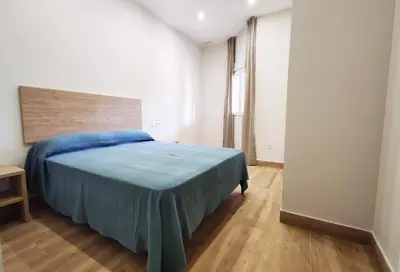 a bedroom with a bed with a blue blanket at APARTAMENTOS SANLUCAR CASA B in Sanlúcar de Barrameda