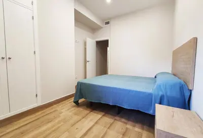 a bedroom with a blue bed and white walls at APARTAMENTOS SANLUCAR CASA B in Sanlúcar de Barrameda