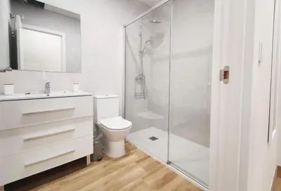 a bathroom with a toilet and a glass shower at APARTAMENTOS SANLUCAR CASA B in Sanlúcar de Barrameda