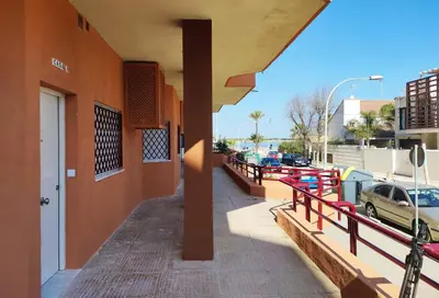 a building with a red railing next to a street at APARTAMENTOS SANLUCAR CASA B in Sanlúcar de Barrameda