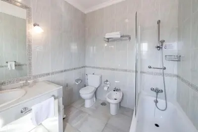 a bathroom with a toilet and a sink and a shower at Hotel El Convento in Arcos de la Frontera