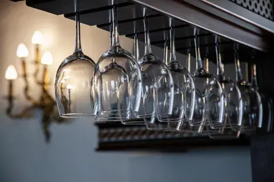 a bunch of wine glasses hanging from a rack at Hotel El Convento in Arcos de la Frontera