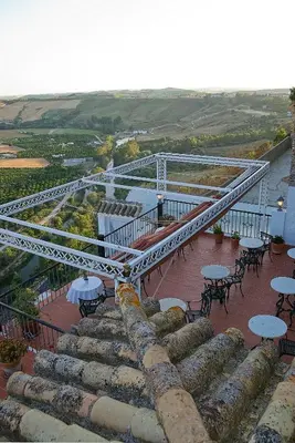 a stairway with tables and tables and chairs on a building at Hotel El Convento in Arcos de la Frontera