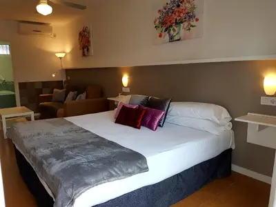 a bedroom with a large bed with red and purple pillows at Campomar Playa in El Puerto de Santa María