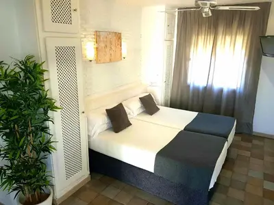 a bedroom with a bed and a window at Campomar Playa in El Puerto de Santa María
