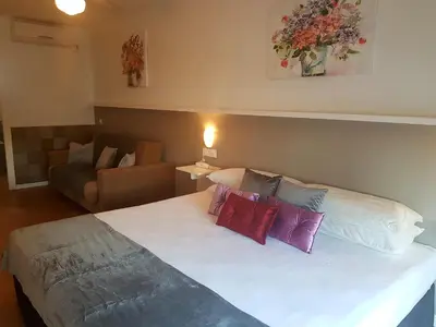 a bedroom with a large white bed with colorful pillows at Campomar Playa in El Puerto de Santa María