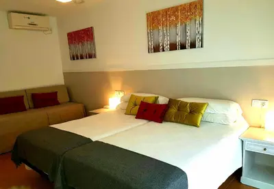 a bedroom with a large bed and a couch at Campomar Playa in El Puerto de Santa María