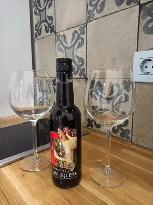 a bottle of wine next to two glasses on a table at Apartamentos La Higuera by VGH in Jerez de la Frontera