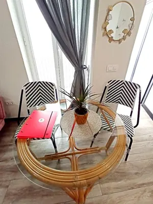 a glass coffee table with two chairs and a potted plant at Apartamentos La Higuera by VGH in Jerez de la Frontera