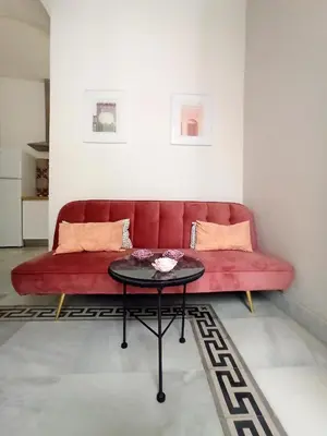 a red couch in a living room with a table at Apartamentos La Higuera by VGH in Jerez de la Frontera