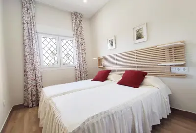 a bedroom with two beds and a window at APARTAMENTOS SANLUCAR CASA D in Sanlúcar de Barrameda