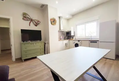 a kitchen with a table and a butterfly on the wall at APARTAMENTOS SANLUCAR CASA D in Sanlúcar de Barrameda