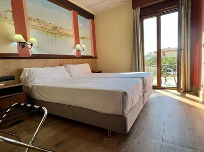 a bedroom with a large bed and a large window at Hotel Pinomar in El Puerto de Santa María