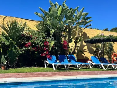 a group of blue chairs next to a swimming pool at Hotel Pinomar in El Puerto de Santa María