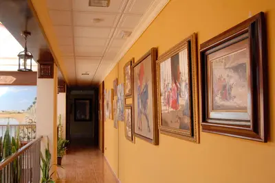 a hallway with a bunch of pictures on the wall at Hotel Pinomar in El Puerto de Santa María