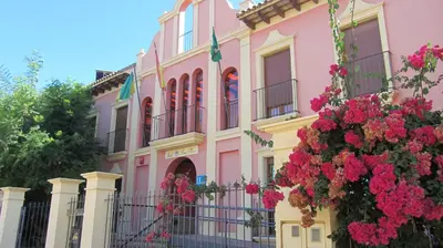 a pink building with flowers in front of it at Hotel Pinomar in El Puerto de Santa María