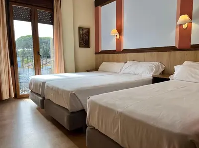a hotel room with two beds and a window at Hotel Pinomar in El Puerto de Santa María