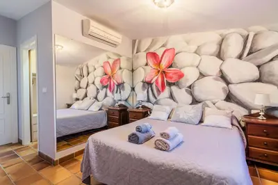 a bedroom with two beds and flowers on the wall at Chalet El Santiscal in Arcos de la Frontera