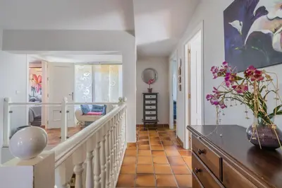 a hallway with a staircase with a vase of flowers at Chalet El Santiscal in Arcos de la Frontera