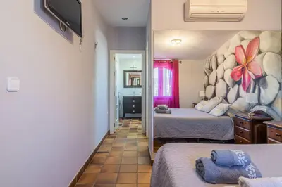 a bedroom with two beds and a mirror at Chalet El Santiscal in Arcos de la Frontera