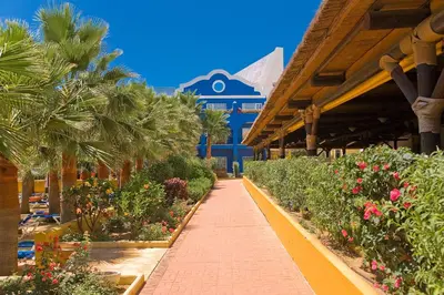 a walkway in front of a building with flowers at Playaballena in Costa Ballena