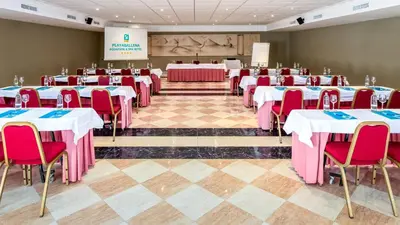 a conference room with tables and chairs and a stage at Playaballena in Costa Ballena
