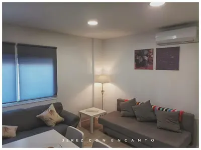 a living room with a couch and a table at Ático en pleno centro de Jerez sin ascensor in Jerez de la Frontera