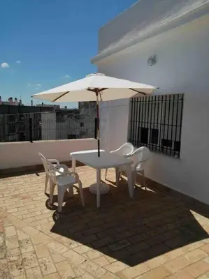 a table and chairs and an umbrella on a patio at Ático en pleno centro de Jerez sin ascensor in Jerez de la Frontera